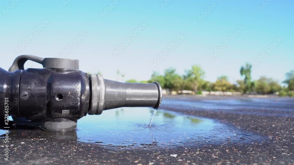 Fire Hose Nozzle on Ground After Putting Out Fire in Parking Lot Fire Hose Nozzle on Ground After Putting Out Fire in Parking Lot