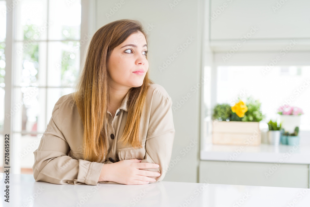 Beautiful young woman at home looking to side, relax profile pose with natural face with confident smile. Beautiful young woman at home looking to side, relax profile pose with natural face with confident smile.