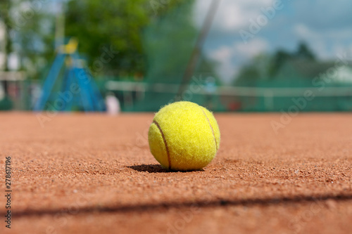 yellow tennis ball on a clay court, tennis infrastructure background © Bonsales