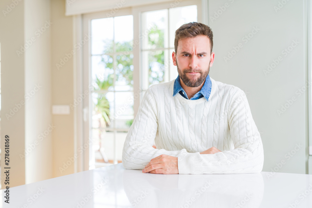 Handsome man wearing casual sweater skeptic and nervous, frowning upset because of problem. Negative person.