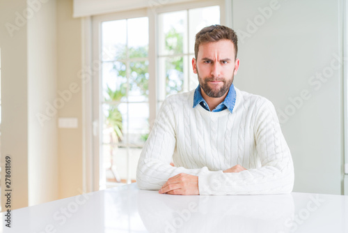 Handsome man wearing casual sweater skeptic and nervous, frowning upset because of problem. Negative person.