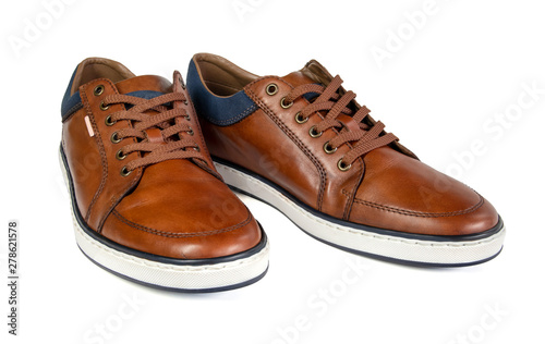 A pair of brown leather trainers on a white background.