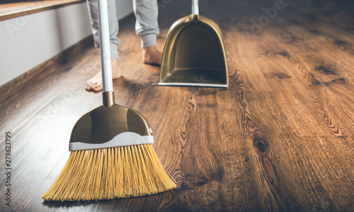 woman hand broom dustpan on the ground photo