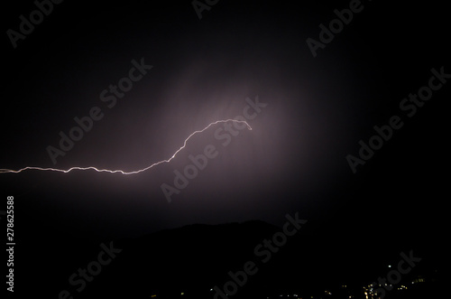 a dangerous storm in a summer night full of lighting bolts with view above the austrian city of leoben to the east