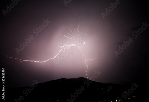 a dangerous storm in a summer night full of lighting bolts with view above the austrian city of leoben to the east