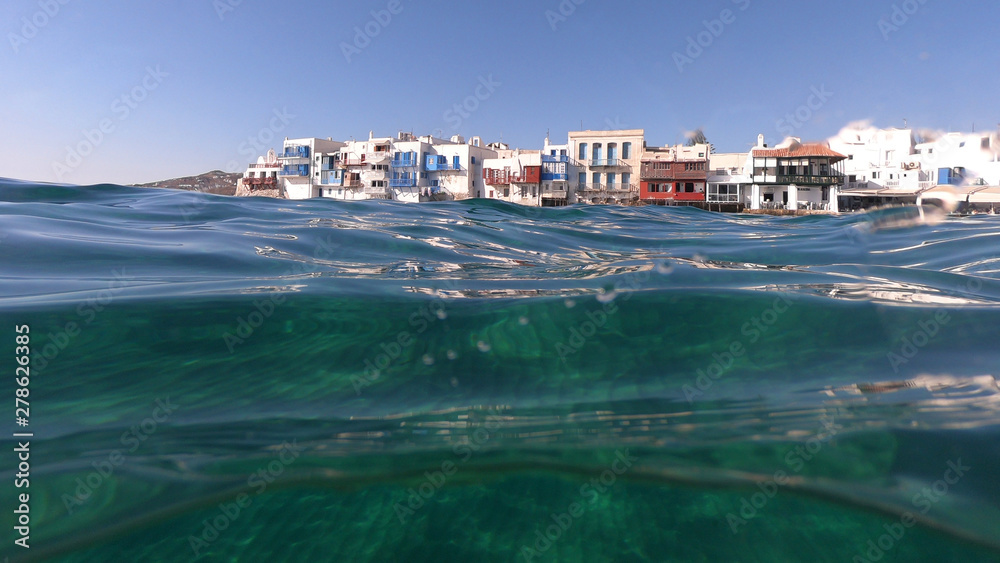 Split of above and underwater photo of iconic and beautiful colourful - whitewashed Little Venice with pure Cycladic architecture, Mykonos island, Greece