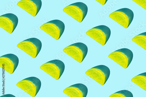 Creative pattern of yellow citrus lemon slices as ice for cocktail on pastel blue background. Pop art minimal flat lay style design, summer drink cold creative concept. Top view, flatlay. Copy space.