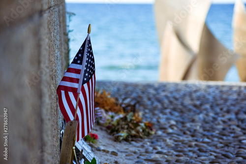 Photography United States flag, flowers and objects in memory of fallen in Normandy landing