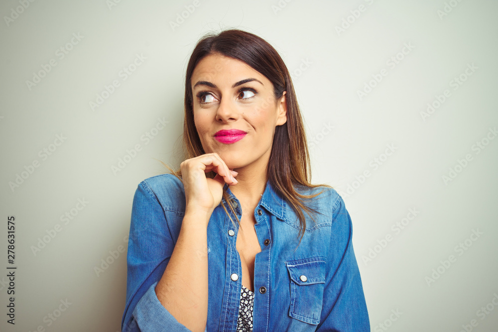 Young beautiful woman standing over isolated background with hand on chin thinking about question, pensive expression. Smiling with thoughtful face. Doubt concept. Young beautiful woman standing over isolated background with hand on chin thinking about question, pensive expression. Smiling with thoughtful face. Doubt concept.
