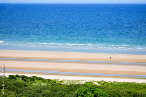 Fototapeta Naklejka Na Ścianę i Meble -  Long calm beach with blue cloudy sky. Omaha Beach. Normandy, France.