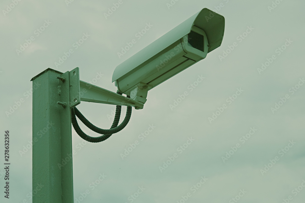 Outdoor security camera with electric cables on an iron pile Outdoor security camera with electric cables on an iron pile