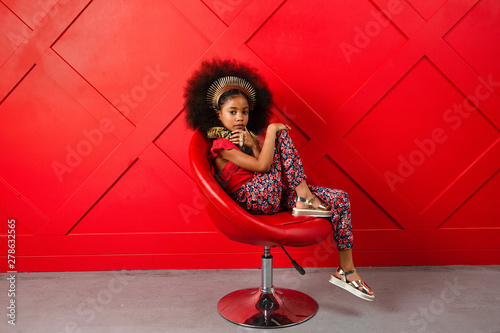 Young girl poses in red themed setting