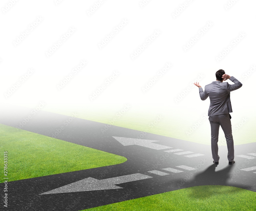 Young businessman at crossroads in uncertainty concept