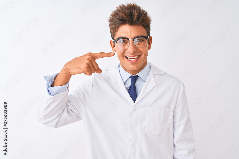 Young handsome sciencist man wearing glasses and coat over isolated white background Pointing with hand finger to face and nose, smiling cheerful. Beauty concept Young handsome sciencist man wearing glasses and coat over isolated white background Pointing with hand finger to face and nose, smiling cheerful. Beauty concept