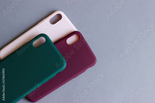 Set of colored silicone cases for the smartphone on the grey background.
