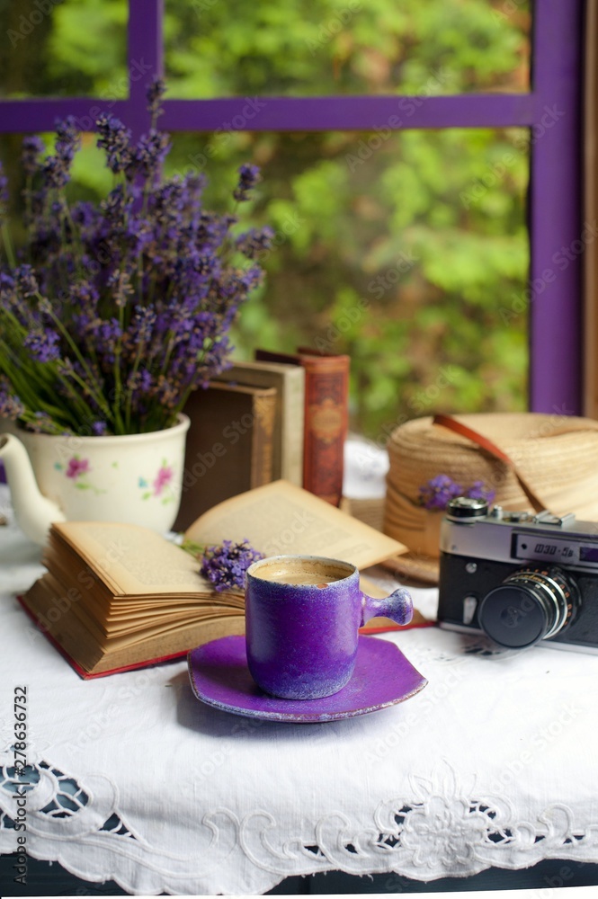 Still life with lavender, coffee in a purple cup, books by the window. Romantic still life with lavender.