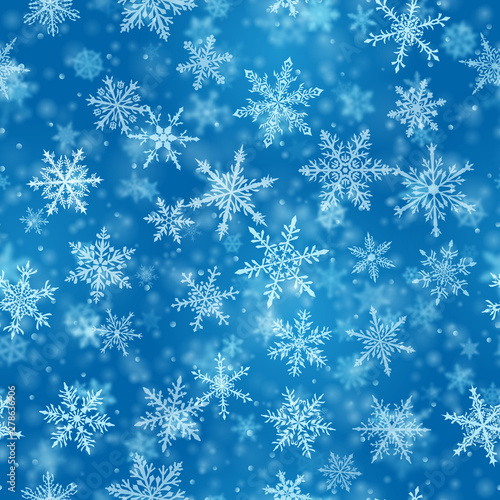 Christmas seamless pattern of complex blurred and clear falling snowflakes in blue colors with bokeh effect