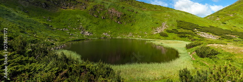 Lake Nesamovite in the Carpathians in the summer sunny day. Alpine lake in the mountains in the summer season. Amazing mountain landscape in mountain valley. Montenegrin Range in the Carpathians. photo