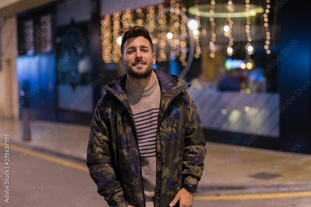 Young handsome man possing and smiling. Street style at night