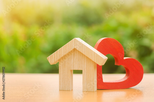 House with a red wooden heart. House of lovers. Parental hospitable home. Housing construction of your dreams. Buying and renting real estate. Affordable housing for young families  support program.