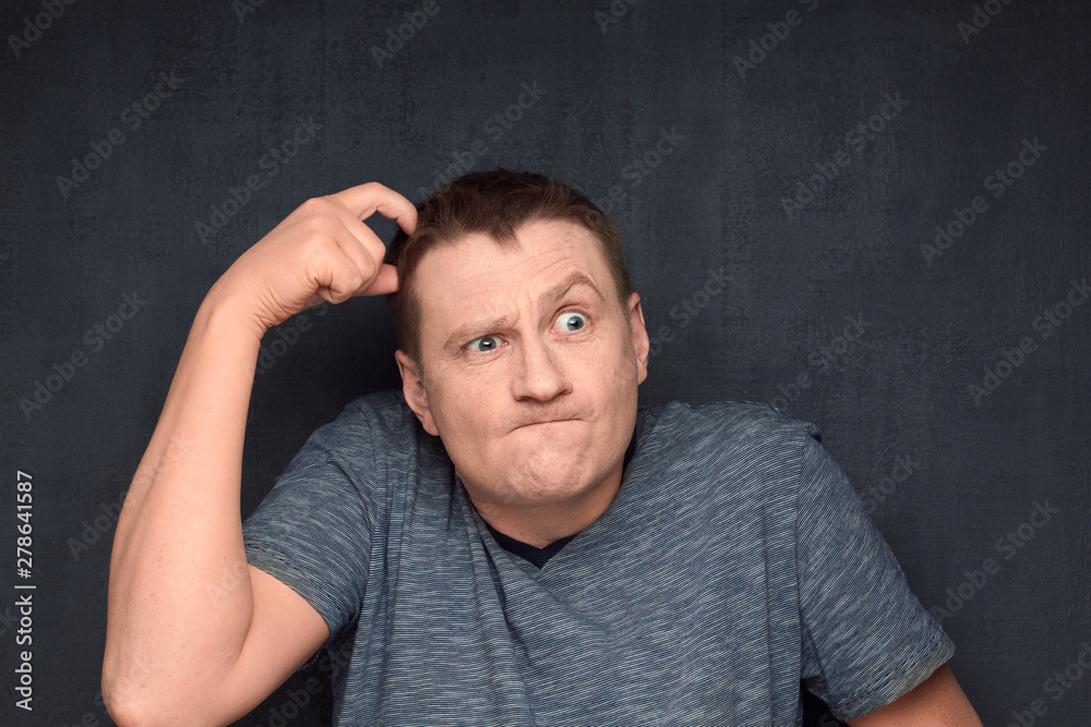 Portrait of man scratching head while trying to solve issue Portrait of man scratching head while trying to solve issue