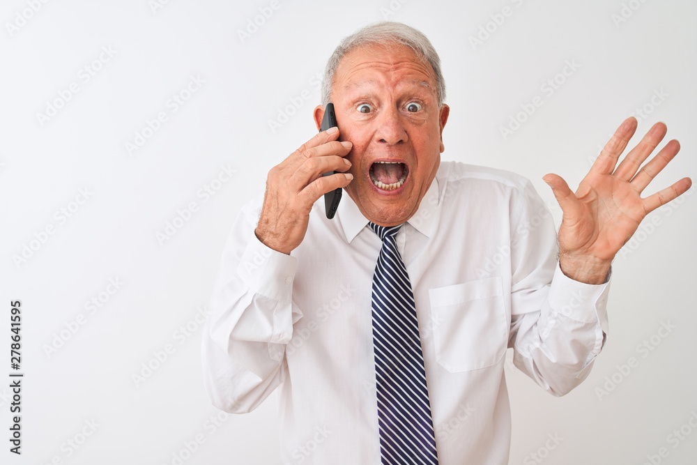 Senior grey-haired businessman talking on the smartphone over isolated white background very happy and excited, winner expression celebrating victory screaming with big smile and raised hands Senior grey-haired businessman talking on the smartphone over isolated white background very happy and excited, winner expression celebrating victory screaming with big smile and raised hands