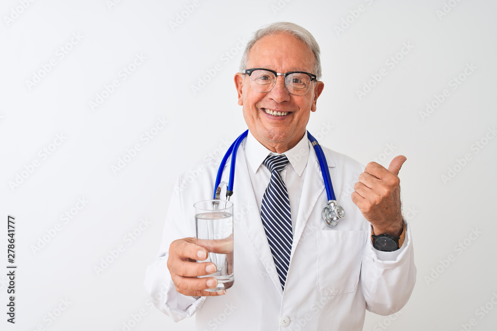 Senior grey-haired doctor man drinking glass of water over isolated white background pointing and showing with thumb up to the side with happy face smiling Senior grey-haired doctor man drinking glass of water over isolated white background pointing and showing with thumb up to the side with happy face smiling