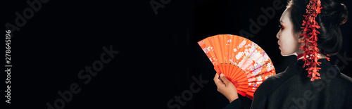 Quadro em tela back view of beautiful geisha in black kimono with red flowers in hair holding t