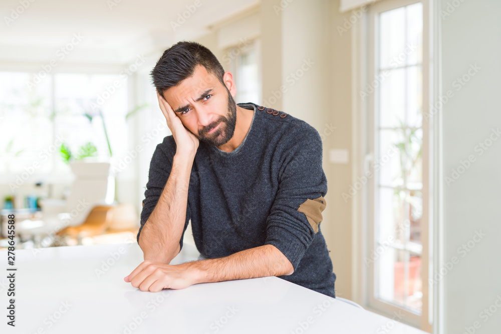Handsome hispanic man wearing casual sweater at home thinking looking tired and bored with depression problems with crossed arms.