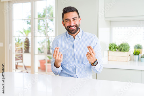 Handsome hispanic business man Doing money gesture with hand, asking for salary payment, millionaire business