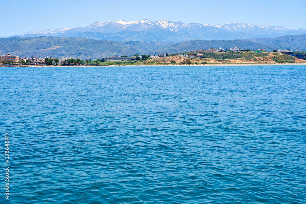 Sea coast of Chania, Crete, Greece with mountains and clear blue sky on a background.