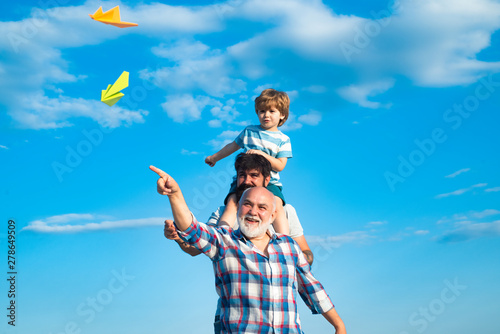 Three men generation. Cute son with dad playing outdoor. Fathers day - grandfather, father and son are hugging and having fun together.