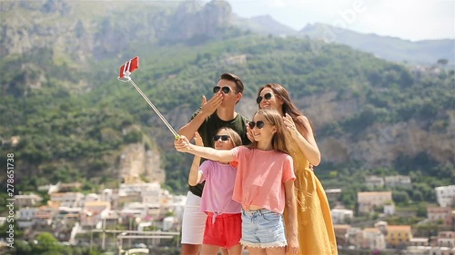 Parents and kids taking selfie photo background Positano town in Itali on Amalfi coast