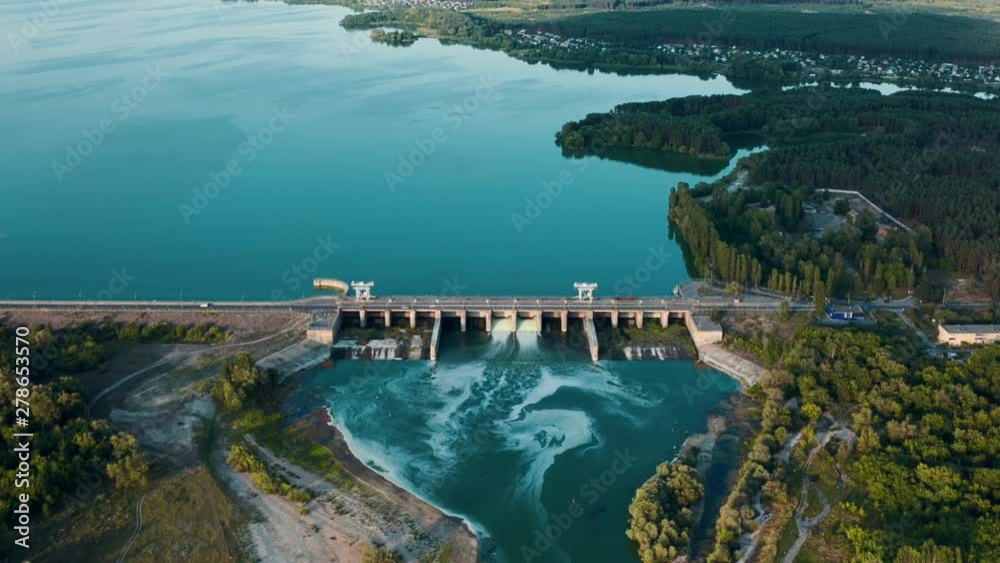 Aerial panoramic view of concrete Dam at reservoir with flowing water, hydroelectricity power station