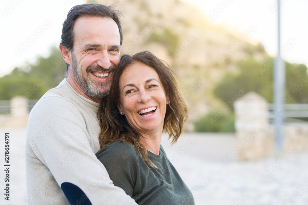 Romantic couple smiling,  cuddling and hugging on a sunny day