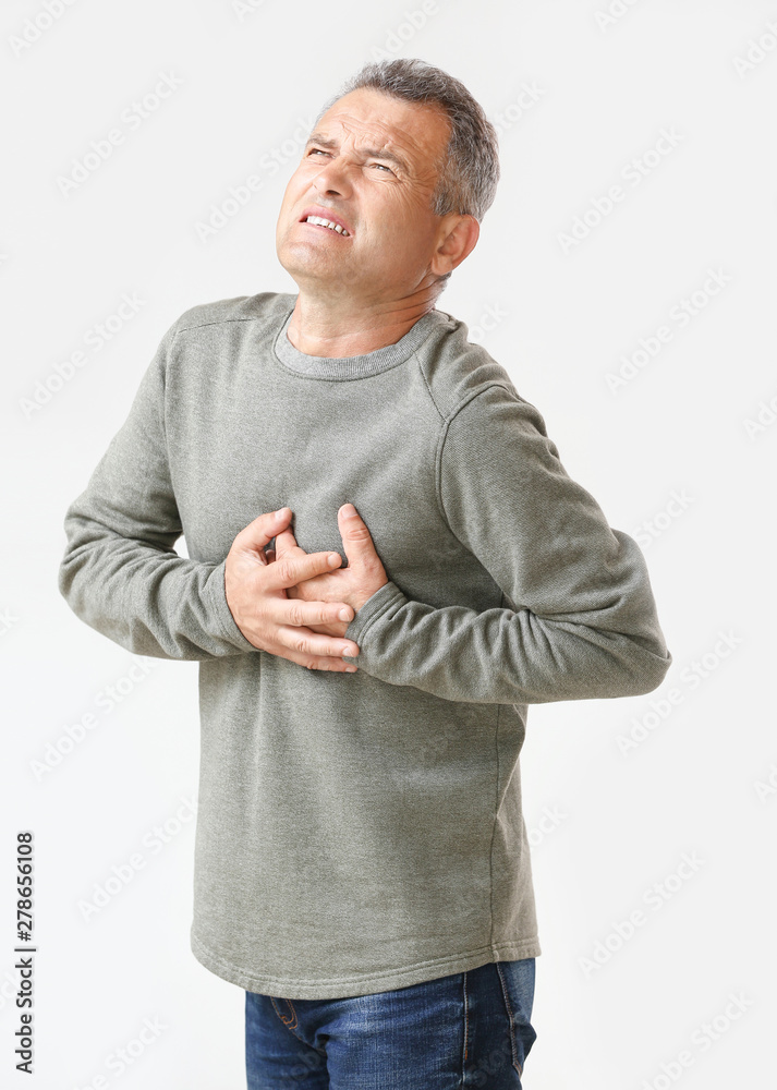 Mature man suffering from heart attack on white background Mature man suffering from heart attack on white background