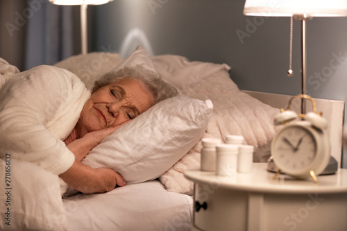 Senior woman sleeping in be...