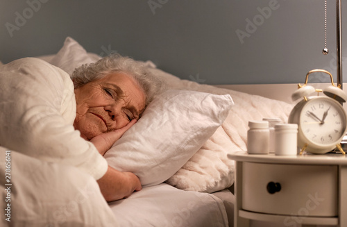 Senior woman sleeping in be...