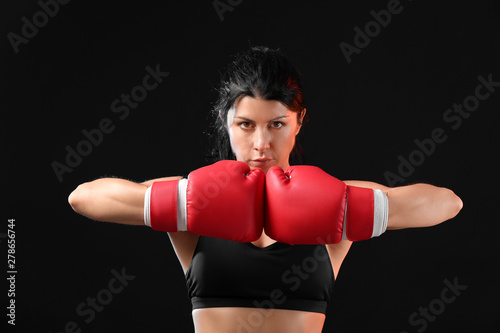 Sporty female boxer on dark background © Pixel-Shot