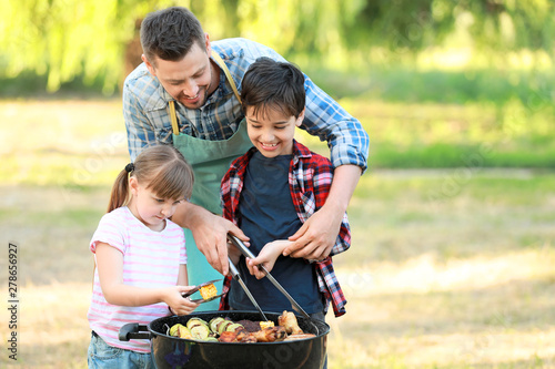 Cuadro en lienzo Little children with father cooking tasty food on barbecue grill outdoors