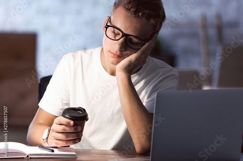 Tired male student preparin...