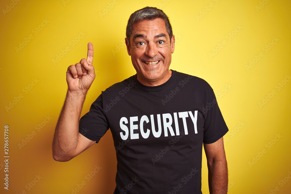Middle age safeguard man wearing security uniform over isolated yellow background surprised with an idea or question pointing finger with happy face, number one Middle age safeguard man wearing security uniform over isolated yellow background surprised with an idea or question pointing finger with happy face, number one