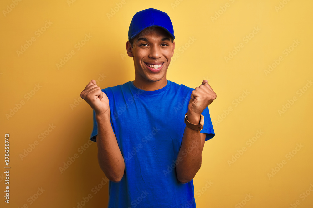 Young handsome arab delivery man standing over isolated yellow background celebrating surprised and amazed for success with arms raised and open eyes. Winner concept.