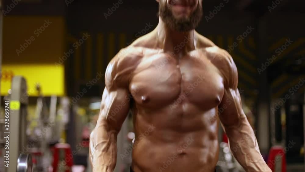 Man in the gym doing biceps standing exercise Man in the gym doing biceps standing exercise
