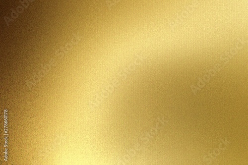 Light shining on gold wave metal plate in dark room, abstract texture background