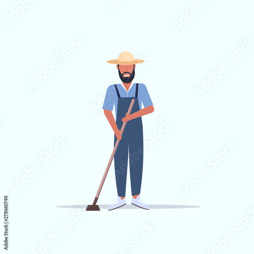 male gardener using hoe countryman hoeing in garden planting harvesting gardening eco farming concept full length