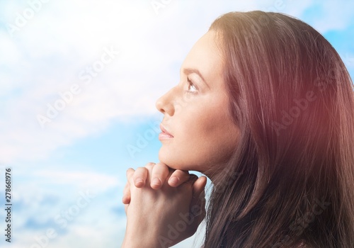 Young Thoughtful woman with hand under chin on background