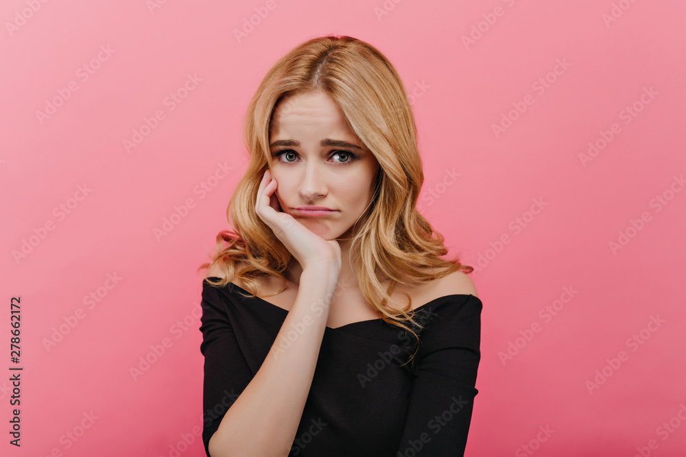 Shy sad girl in black clothes propping face with hand. Indoor portrait of  adorable upset blue-eyed woman posing on pink background. Stock Photo |  Adobe Stock