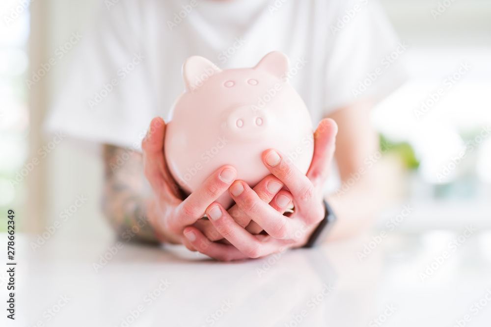 Close up of man holding piggy bank, saving money for investment Close up of man holding piggy bank, saving money for investment
