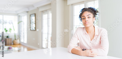 Wide angle of beautiful african american woman with afro hair looking sleepy and tired, exhausted for fatigue and hangover, lazy eyes in the morning.